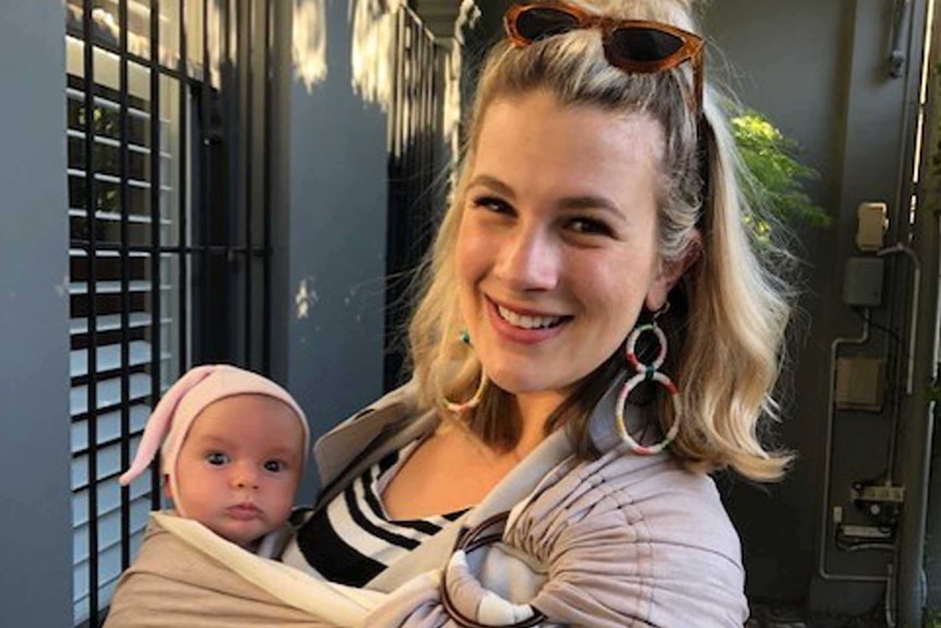 Grace Jennings-Edquist holding her eight-week-old baby in a sling