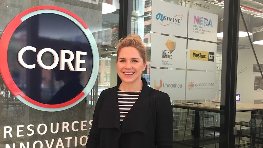 Tamryn Barker in front of sign for CORE Resources Innovation Centre