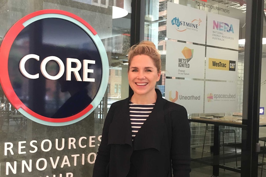 Tamryn Barker in front of sign for CORE Resources Innovation Centre