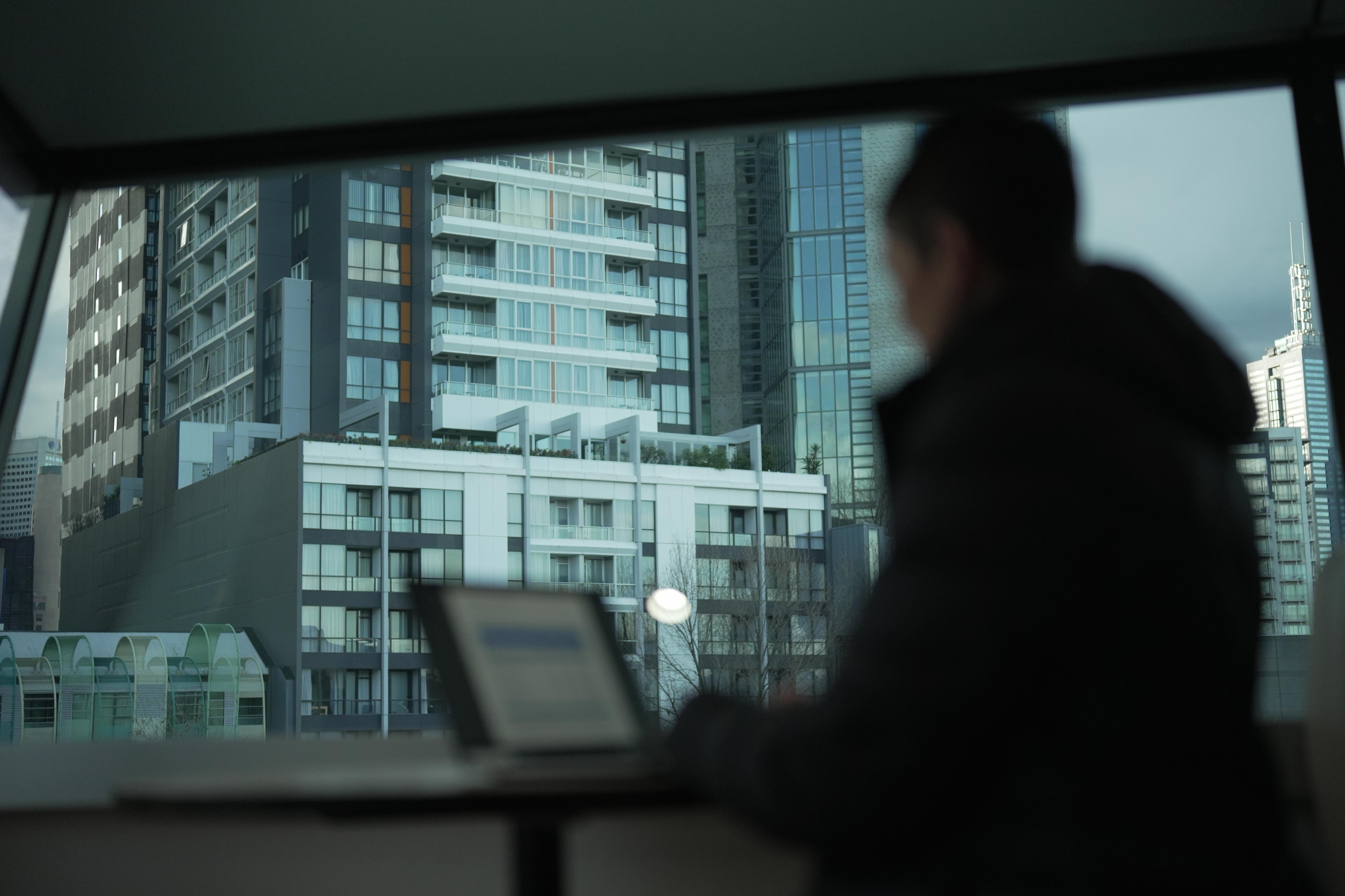 A woman sits in front of a laptop