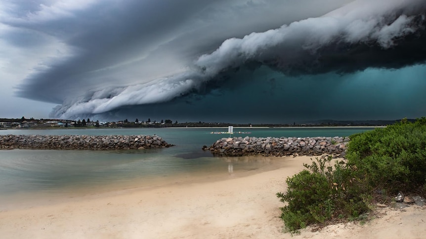 looming shelf cloud bears down on beach with eerie green glow