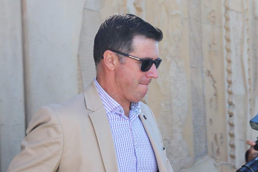 Tight-lipped suspended Ipswich mayor Andrew Antoniolli leaves Ipswich Magistrates Court wearing sunglasses.