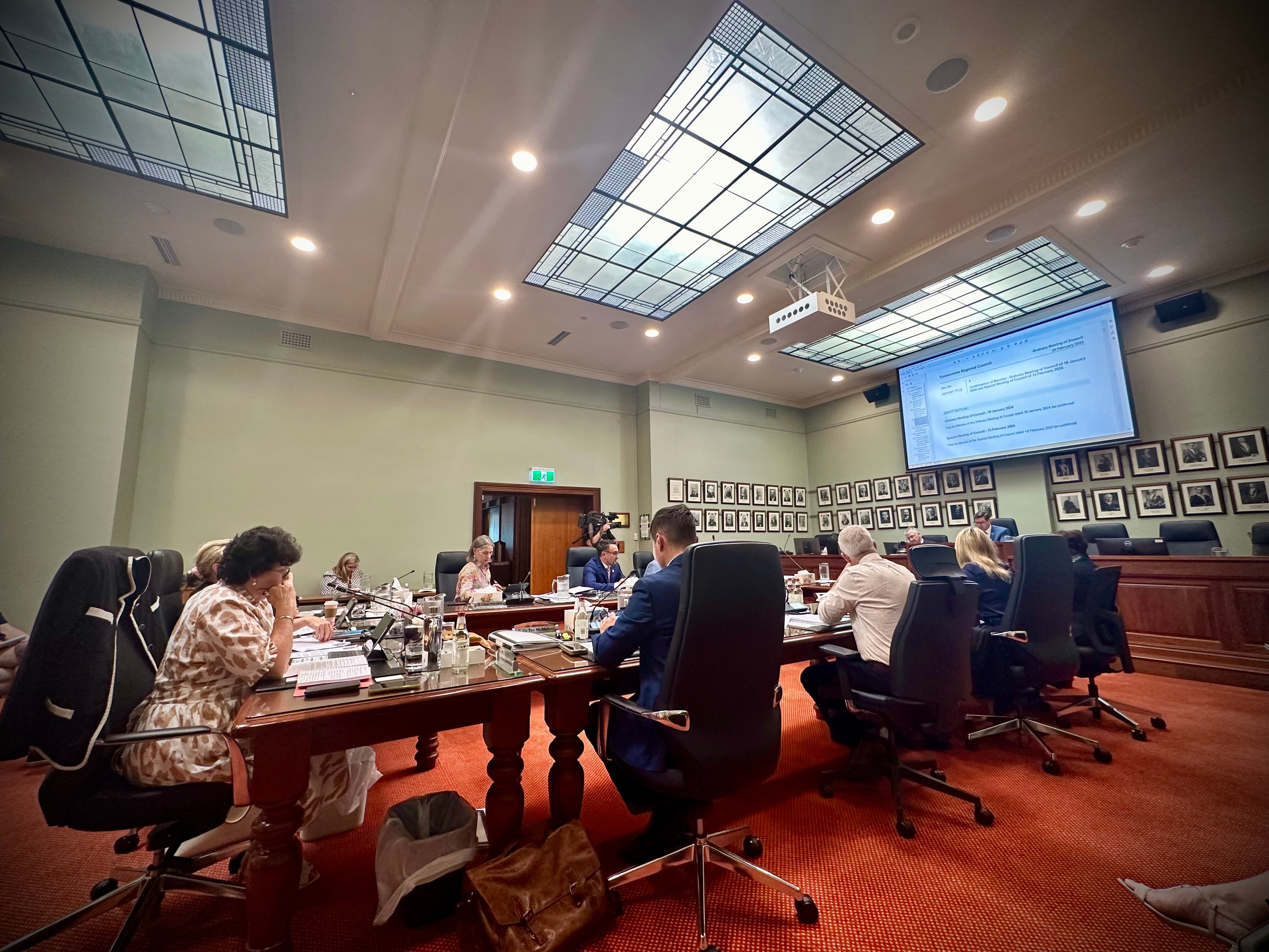 A board table with men and women sitting around it