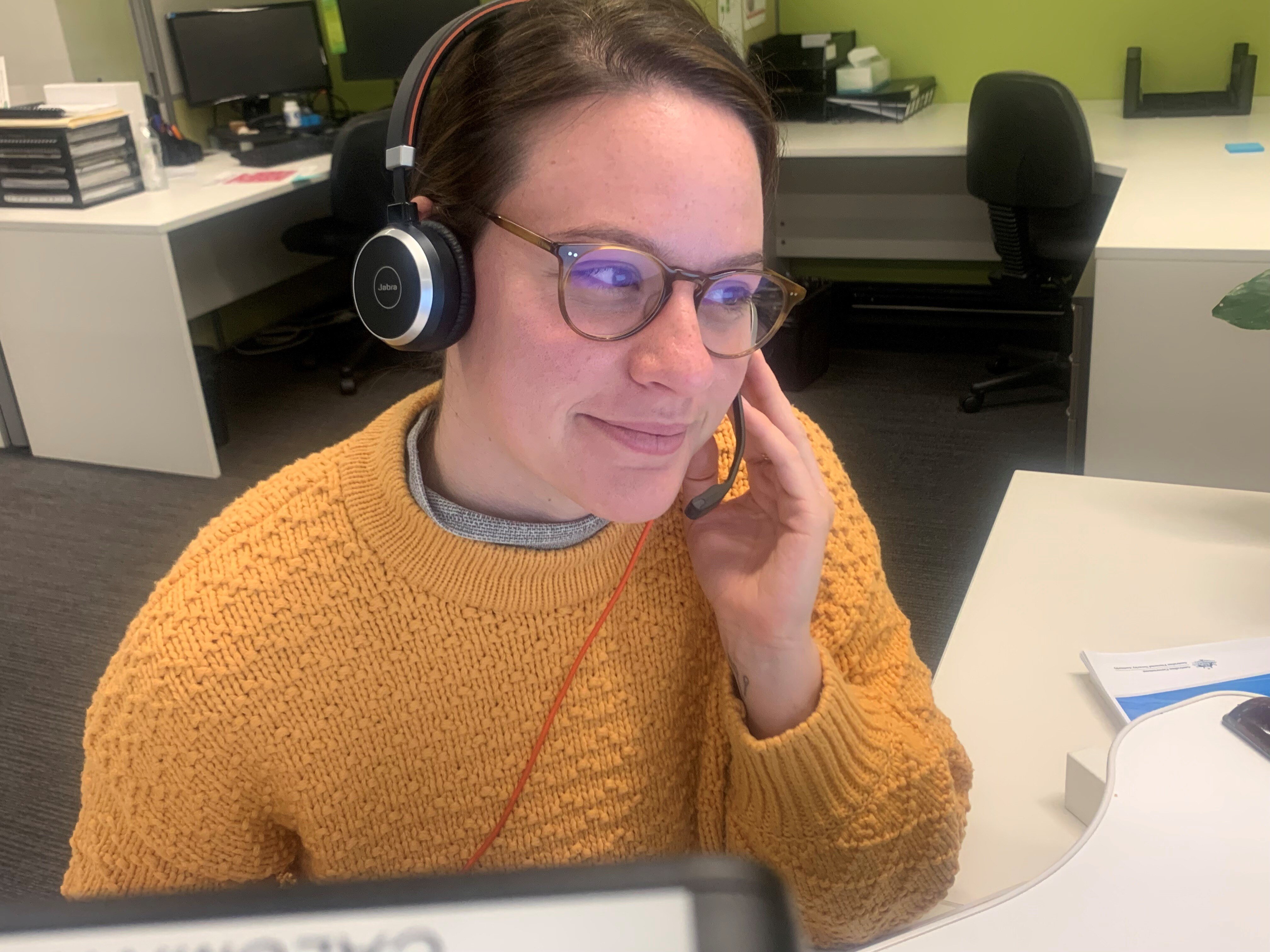 A woman at a desk with a headset on.