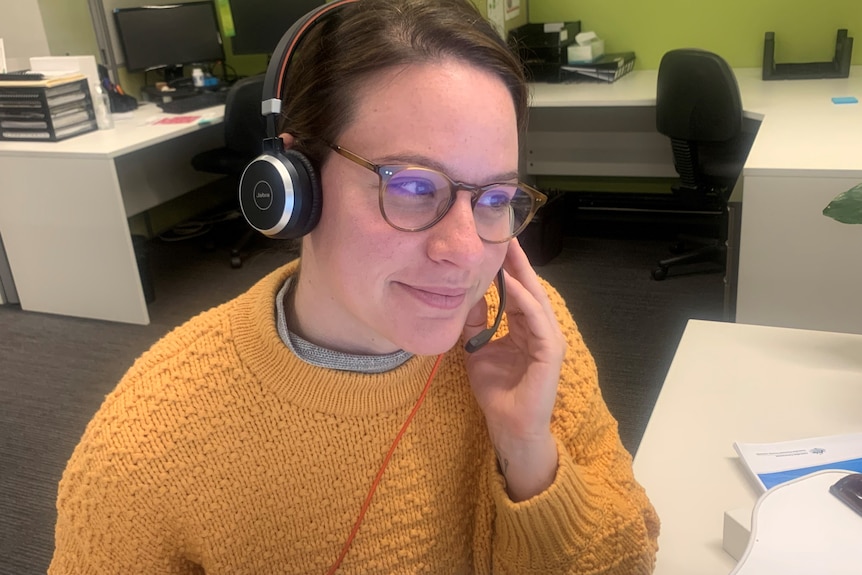 A woman at a desk with a headset on.