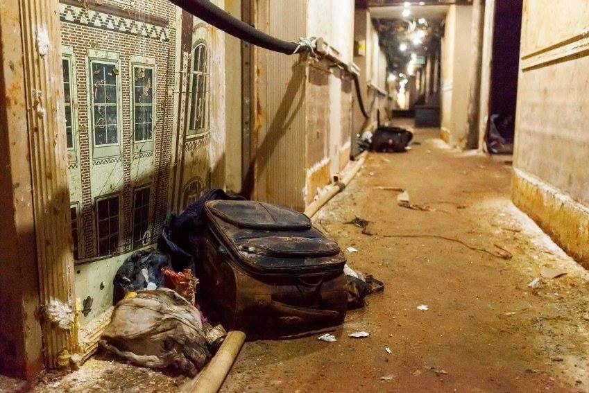 Water-damaged luggage and debris inside a corridor.