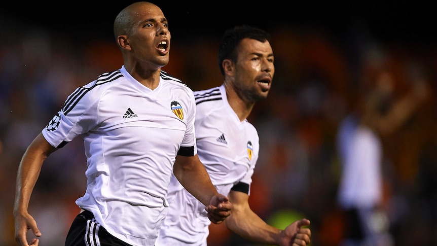 Valencia's Sofiane Feghouli (L) scores goal against Monaco in Champions League play-off first leg.