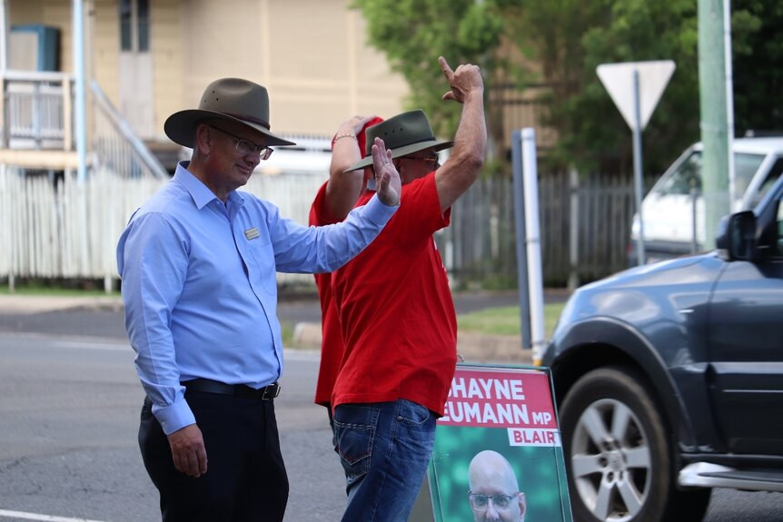 Labor candidate Shayne Neumann for Blair waving to motorists while on the hustings in the 2022 election campaign