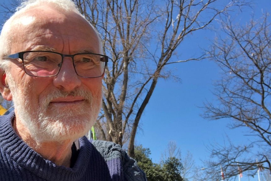 Peter Skinner sits on a blue-sky day.