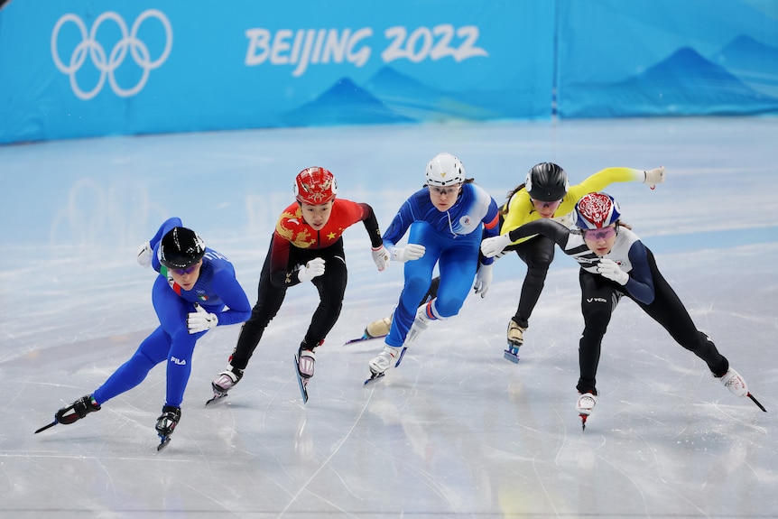 Cinco atletas compiten durante los cuartos de final de patinaje de velocidad de 500 m femeninos en los Juegos Olímpicos de Beijing. 