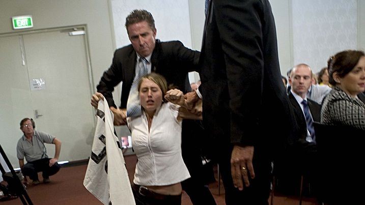 A protester is dragged out of the National Press Club in Canberra