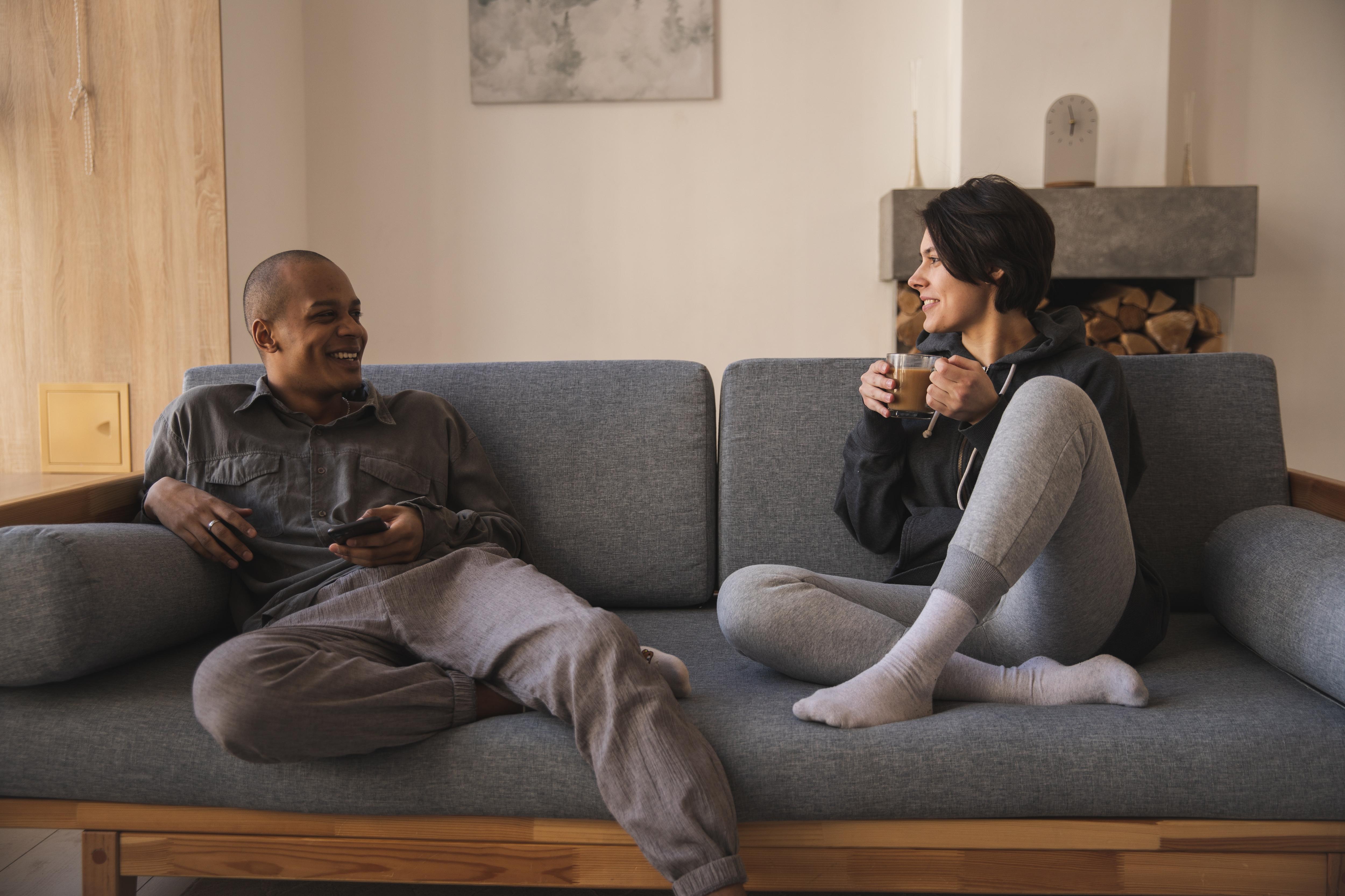 Man and woman sitting on couch chatting in a story about how men benefit from talking about their feelings