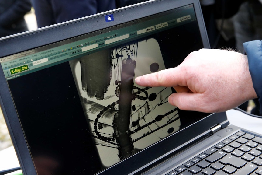 An engine in the frame of a bike is seen in an X-ray displayed on a laptop