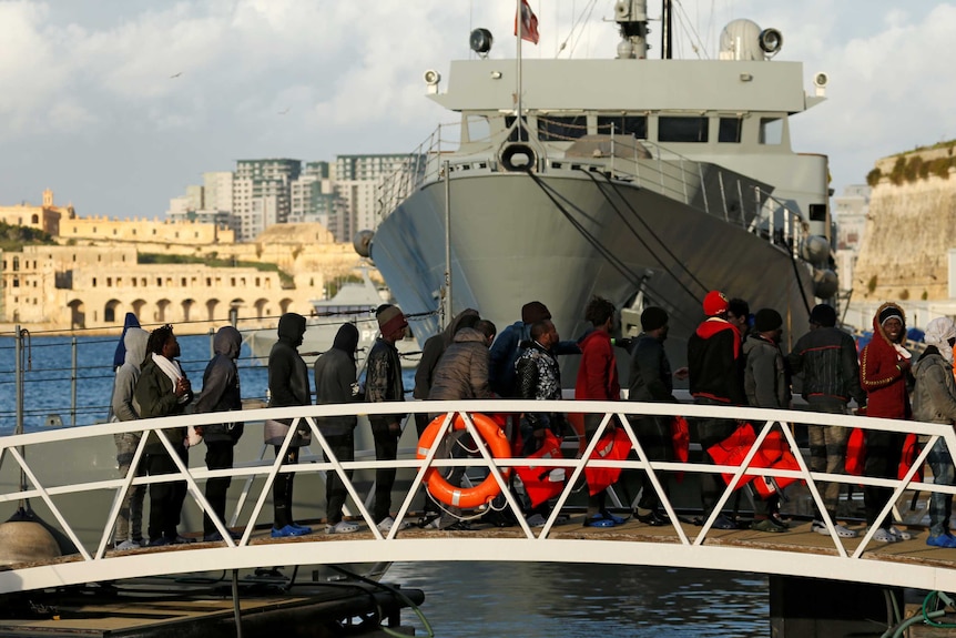 Migrants who were stranded on the NGO migrant rescue ships Sea-Watch 3 disembark from an Armed Forces of Malta patrol boat.