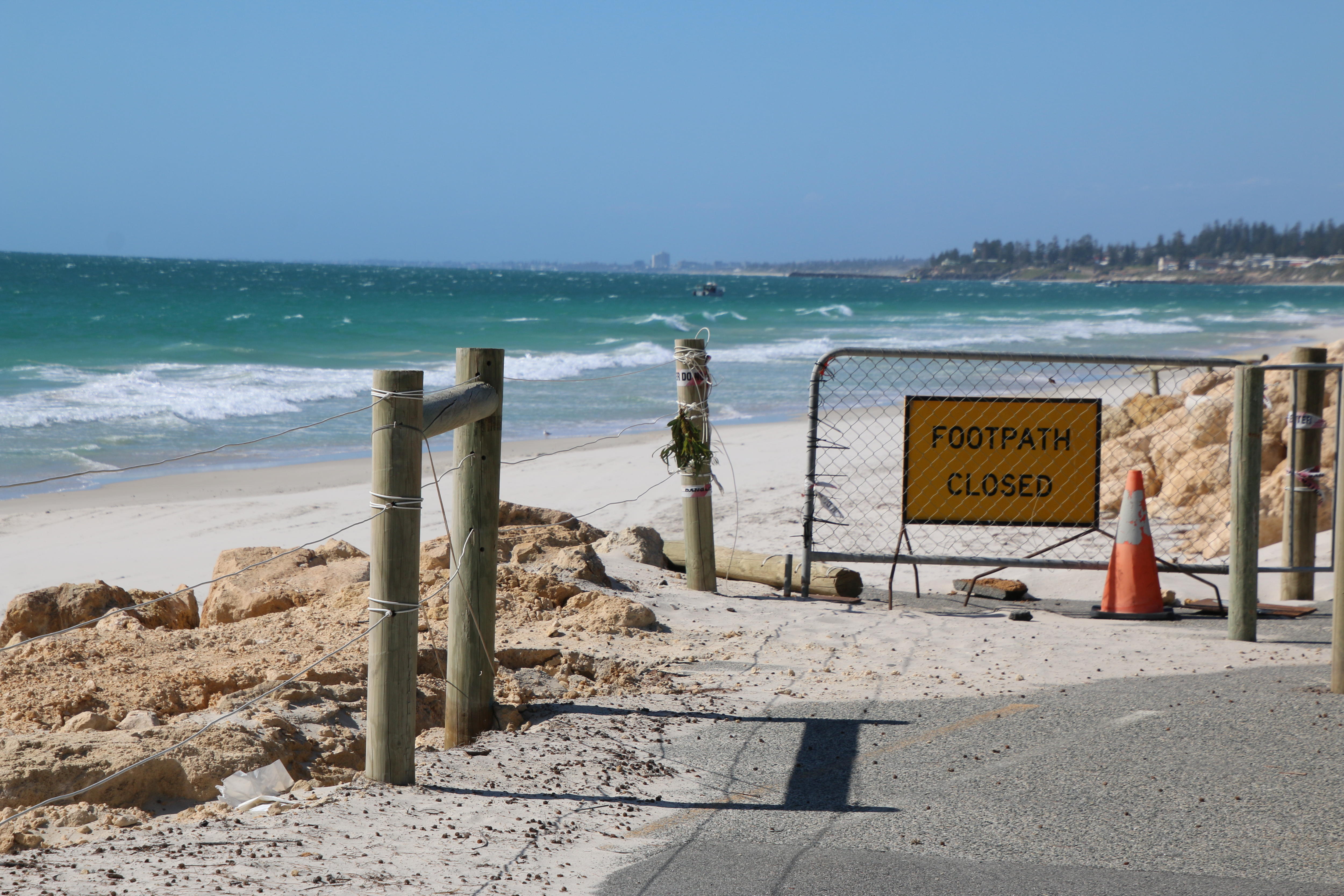 Footpath closed sign on a fence at the beach