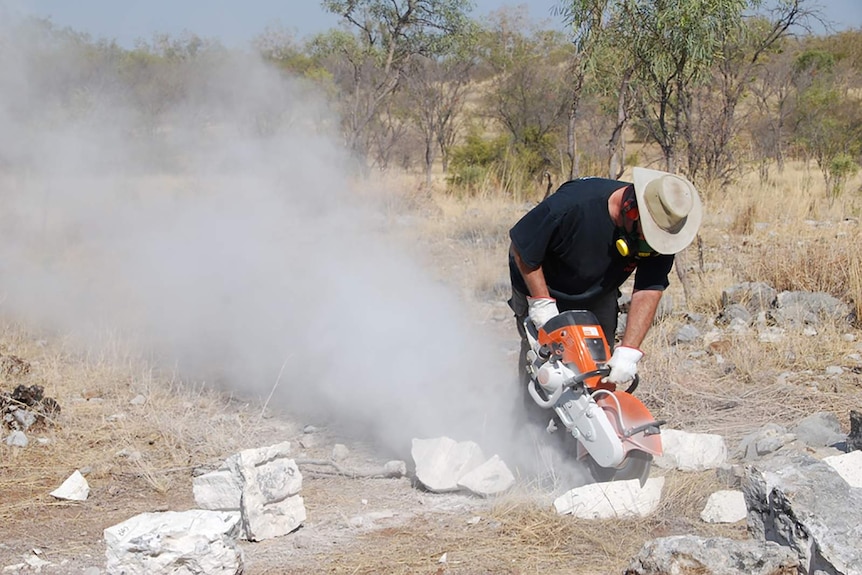A photo of someone using an electric saw to cut down limestone.