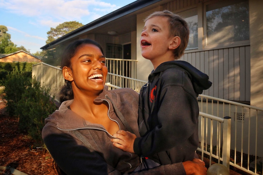 Veena Wijewickrema carrying a young boy called Lachie.