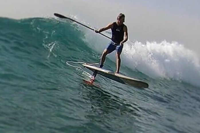 La planche de Brenden Clark planant au-dessus de la vague sur un foil.