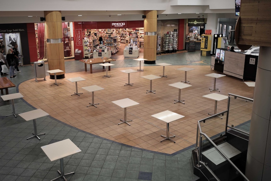 Empty tables in a deserted food court.