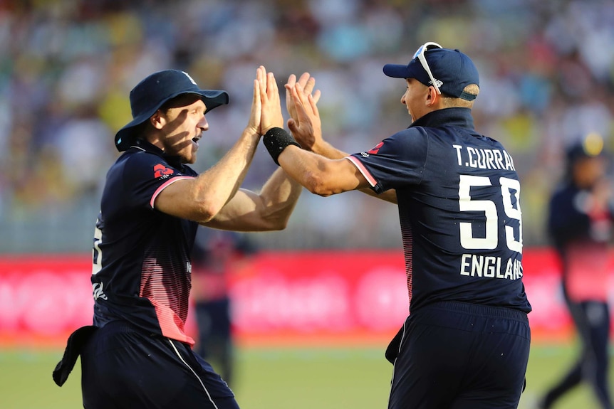 England cricket players Tom Curran and David Willey celebrate on the field at Perth Stadium.