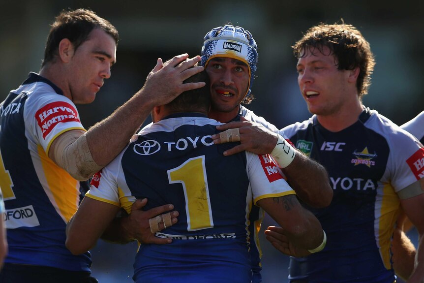 Well done ... Johnathan Thurston hugs team-mate Matt Bowen