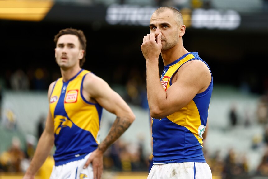 Dom Sheed holds his hand to his face as he walks off the field