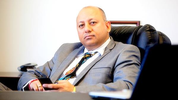 Avniesh Bhardwaj sitting at his desk in a leather chair