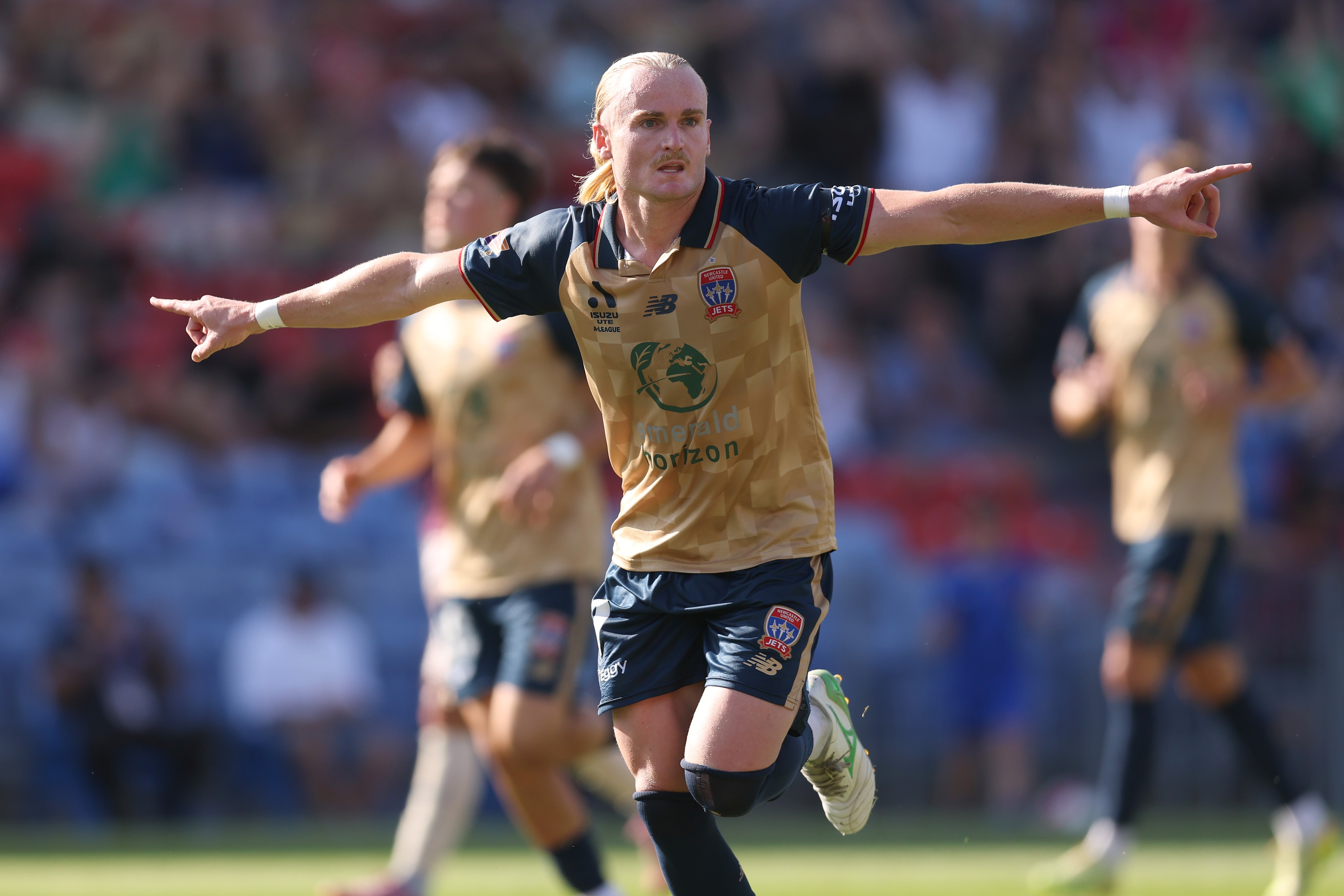 Lachlan Rose estica os braços em comemoração após marcar para o Newcastle Jets