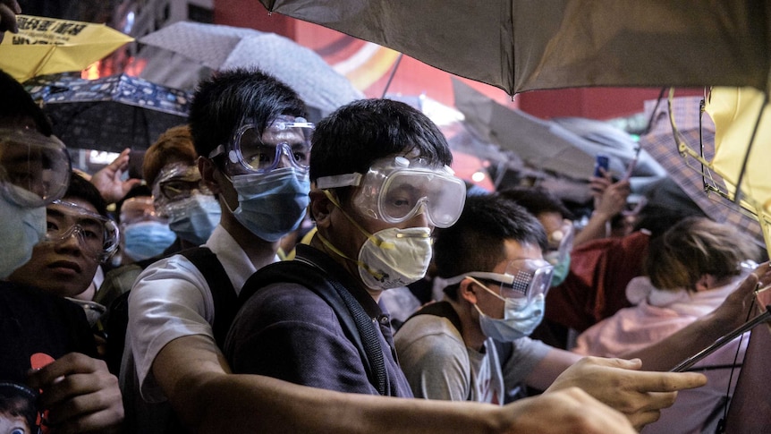 Pro-democracy protesters wear face masks to protect them from pepper spray