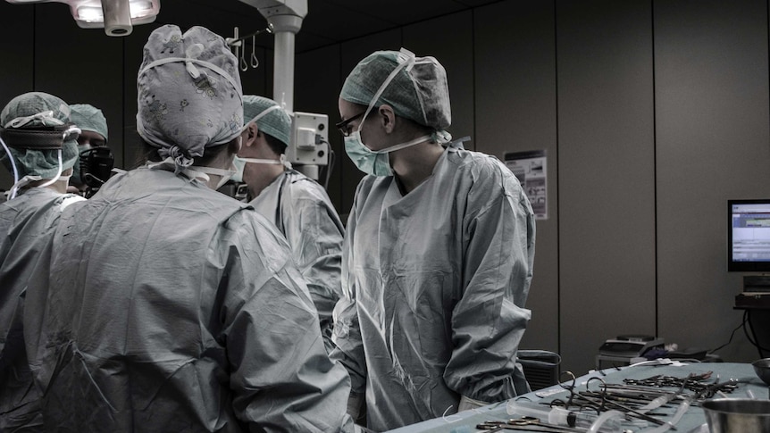 Surgery staff stand around a hospital bed in Brussels, Belgium.