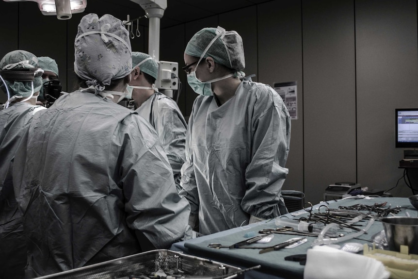 Surgery staff stand around a hospital bed in Brussels, Belgium.