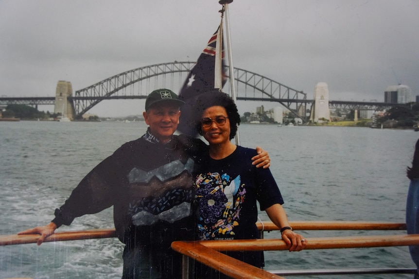 An old photo of Cam and her husband Dan, with the Sydney Harbour Bridge in the background