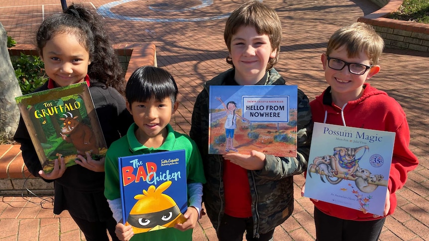 Four children standing with new books