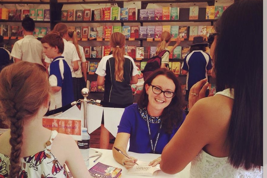 Samantha signing books in bookshop.