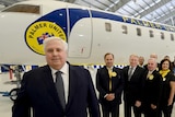 Clive Palmer stands in front of his campaign jet along with his party's Queensland federal election candidates.