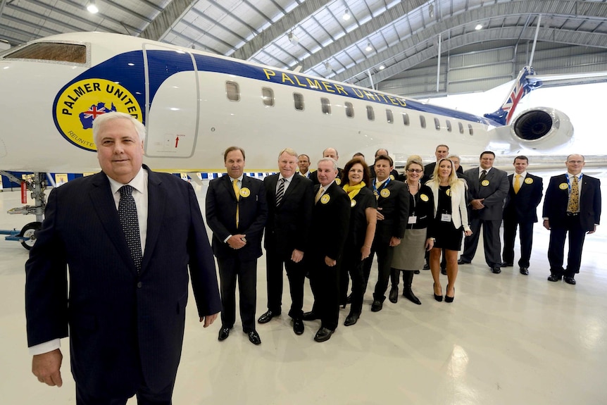 Clive Palmer stands in front of his campaign jet along with his party's Queensland federal election candidates.