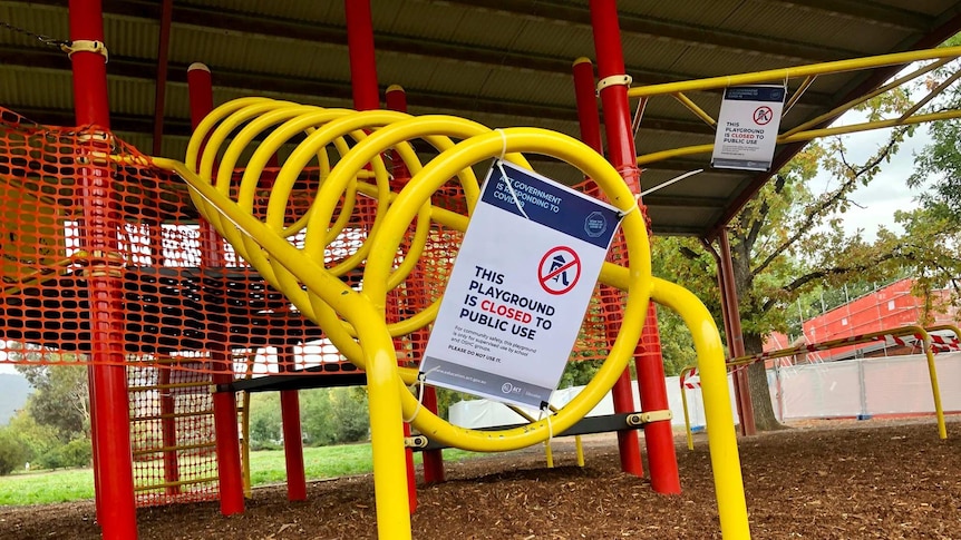 A sign stuck to an empty playground in Canberra's suburbs says it's closed