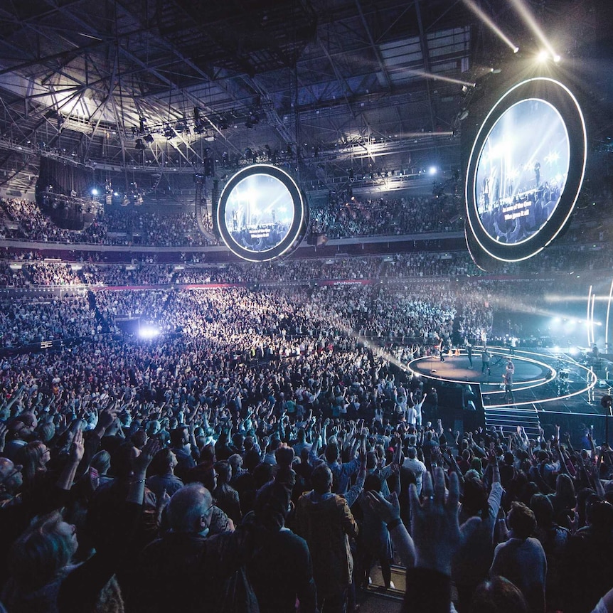 Lighting and music draw thousands of people for a Hillsong service.