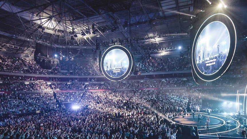 Lighting and music draw thousands of people for a Hillsong service.