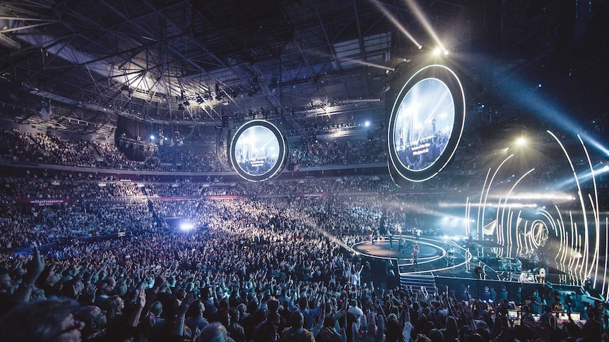 Lighting and music draw thousands of people for a Hillsong service.