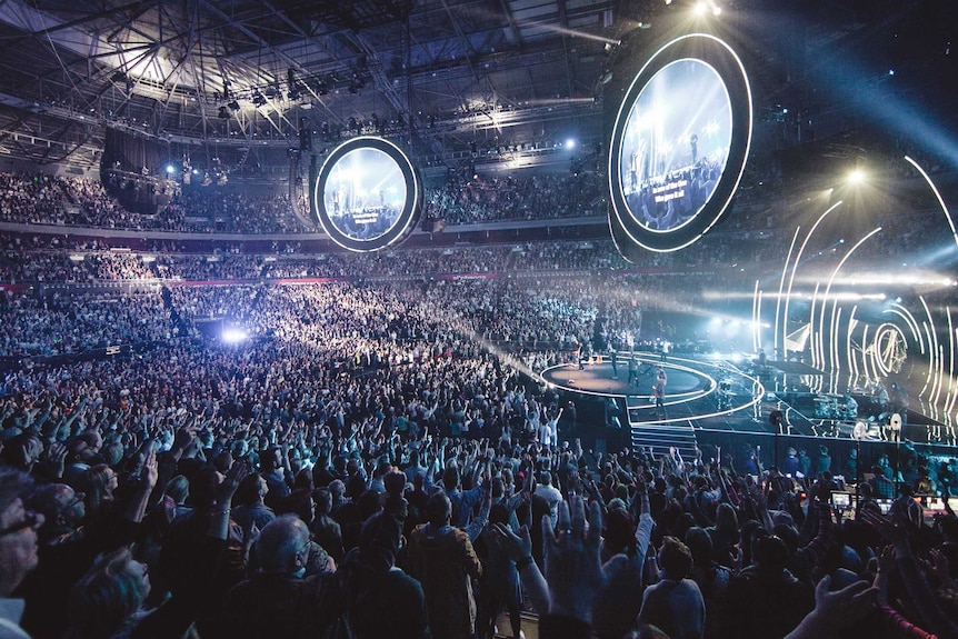 Lighting and music draw thousands of people for a Hillsong service.