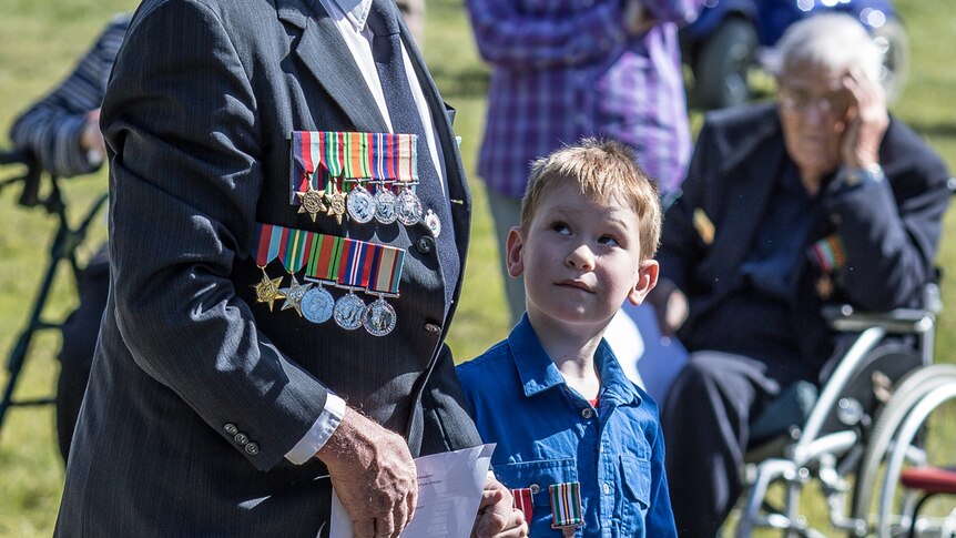 Young boy and old man, both wearing medals