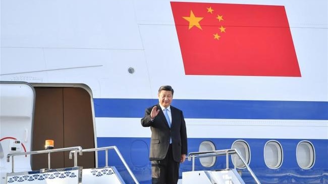Chinese President Xi Jinping waves as he arrives in North Korea for talks with Kim Jong Un.