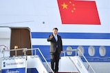 Chinese President Xi Jinping waves as he arrives in North Korea for talks with Kim Jong-un.