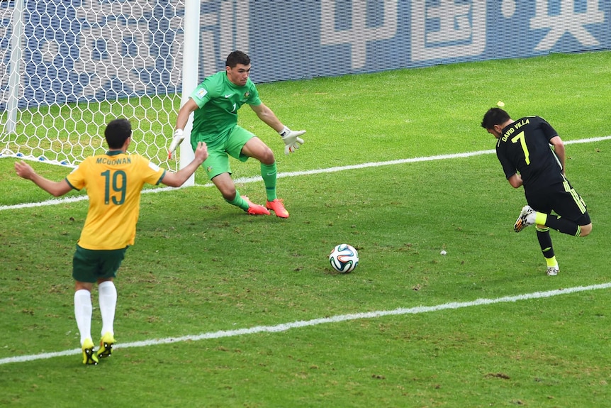 David Villa of Spain scores with a back heel past Mathew Ryan