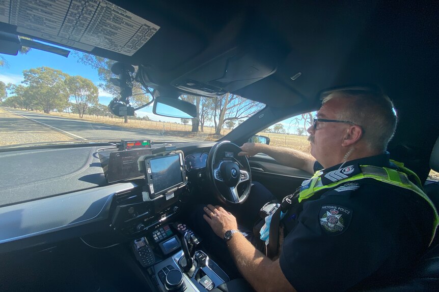 A police officer driving a police car 
