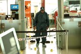 A police officer walks through the scene at Sydney airport where a man was bludgeoned to death