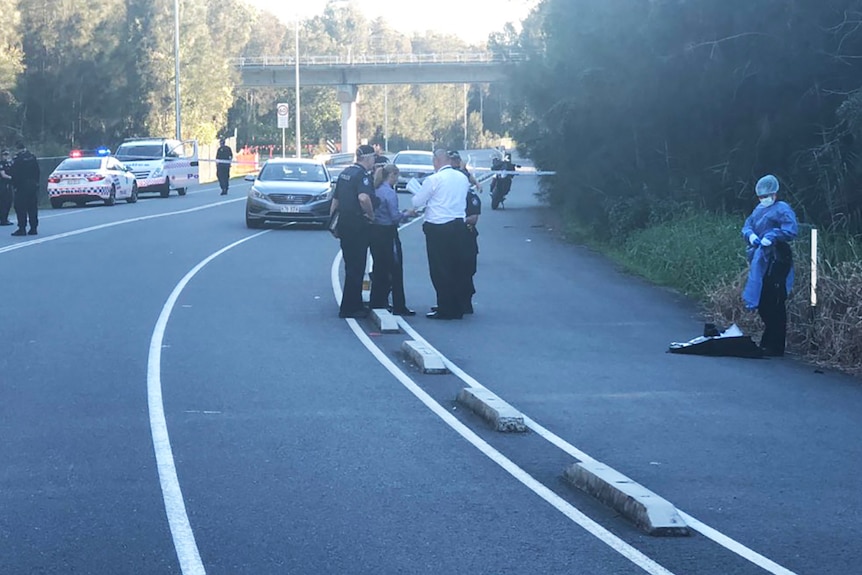 Police on a Gold Coast road where a shooting victim was found