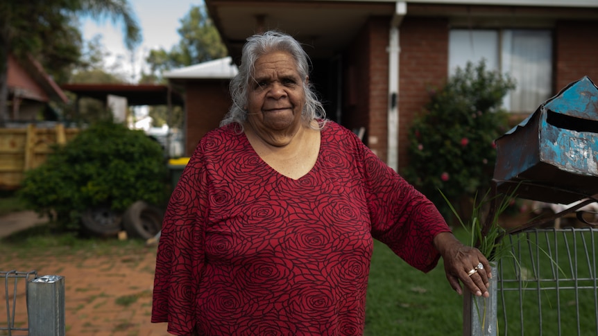 A woman standing outside a home.