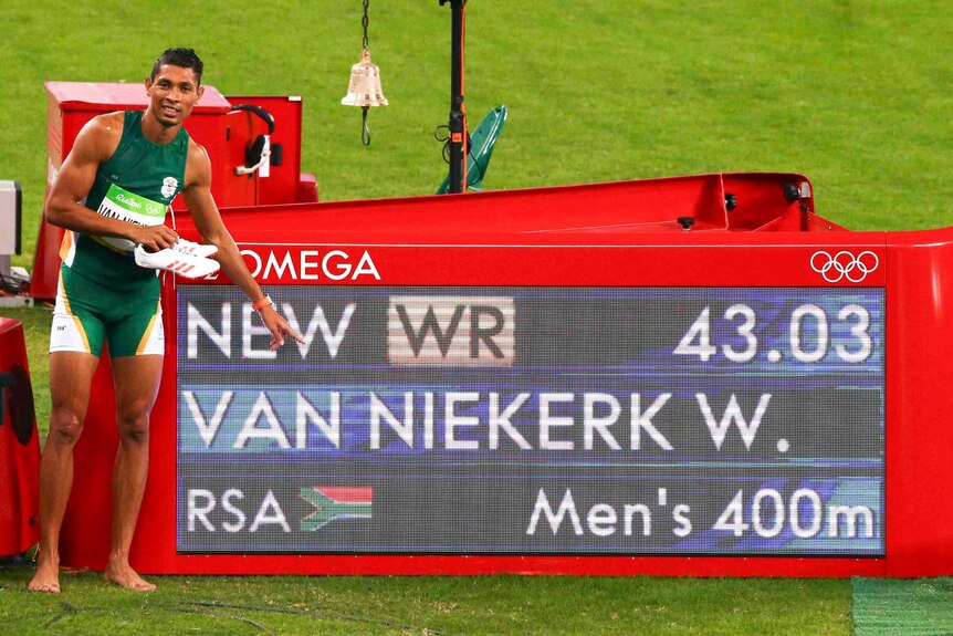 Wayde van Niekerk of South Africa poses next to his winning time at the Rio Olympics 400m final.